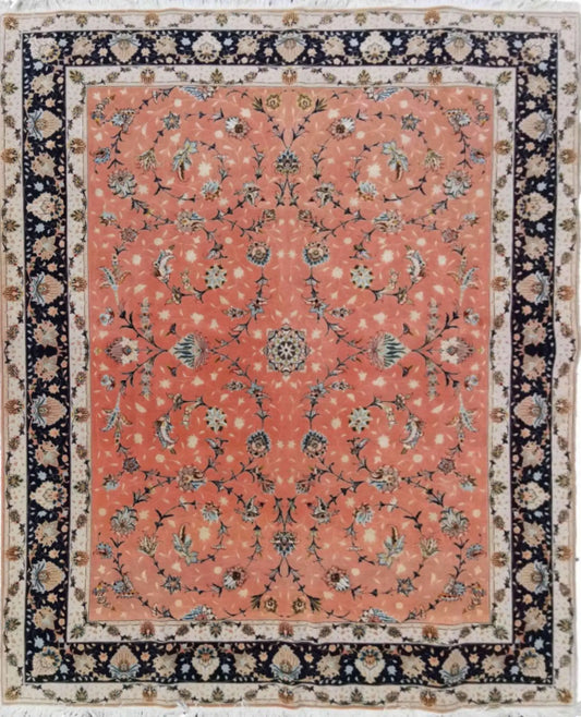 A traditional Tabriz salmon pink wool and silk rug with a geometric and floral pattern, featuring a central medallion and a dark border.