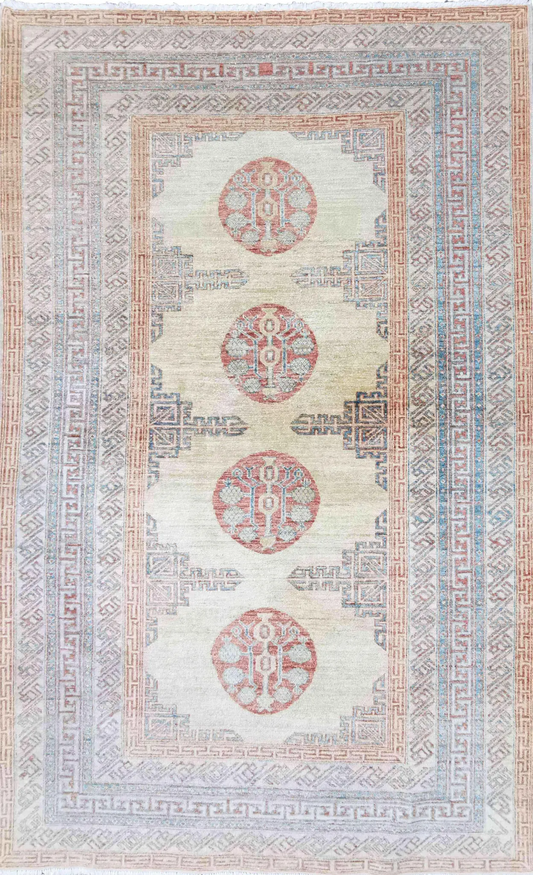 A Kazak wool rug featuring a geometric pattern with bold angles, primarily beige with red accents, and decorative elements along the borders.