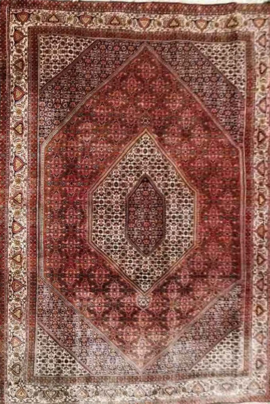 A Persian Bidjar red rug with a central medallion and geometric patterns