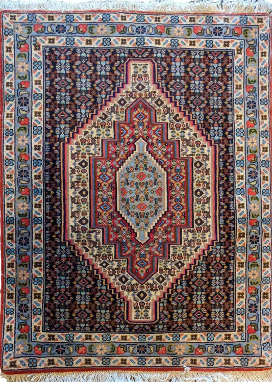 A Persian Senneh traditional wool rug with a geometric and floral pattern, predominantly brown with blue accents.