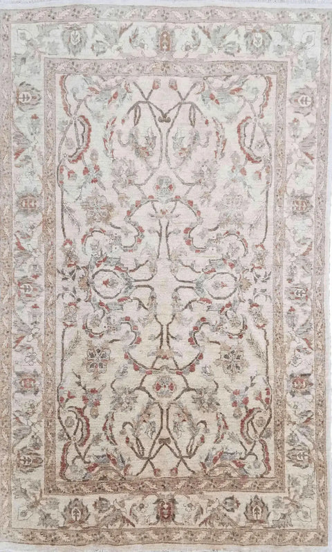 A beige wool rug with brown secondary accents, featuring intricate floral designs and a traditional Persian influence in the pattern.