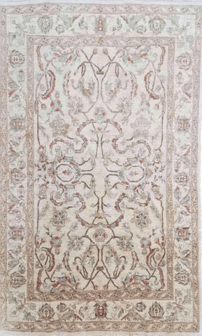 A beige wool rug with brown secondary accents, featuring intricate floral designs and a traditional Persian influence in the pattern.