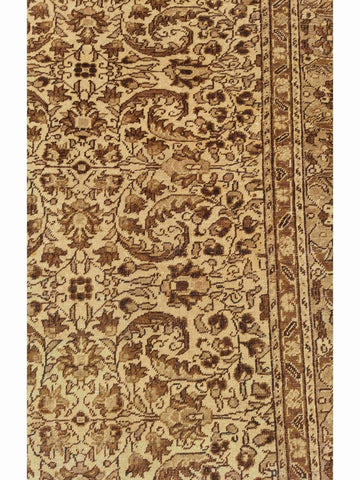 A beige and brown colored wool rug with a traditional geometric pattern.
