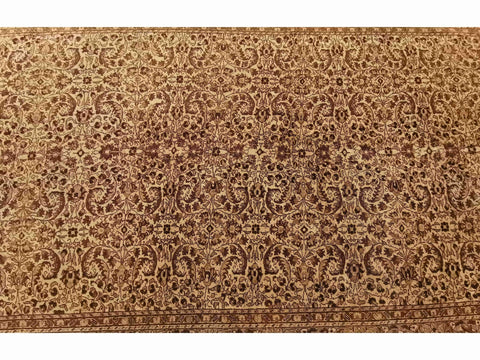 A beige and brown colored wool rug with a traditional geometric pattern.