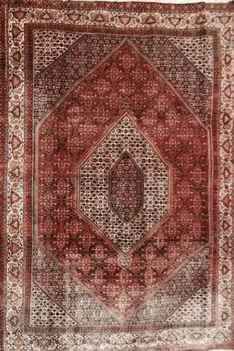 A Persian Bidjar red rug with a central medallion and geometric patterns