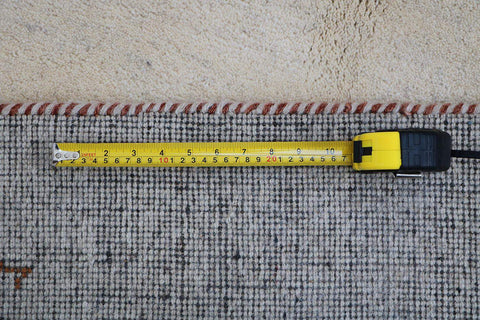 Gabbeh Tribal Wool Rug with a primarily cream color and small beige patterns throughout.