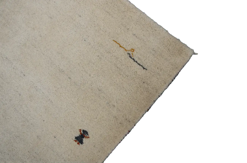 Gabbeh Tribal Wool Rug with a primarily cream color and small beige patterns throughout.