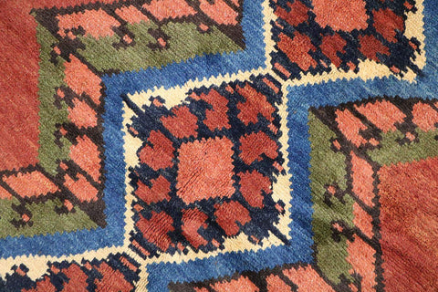 A geometric patterned Afghan Tribal Wool Rug in beige, red, and other colors.