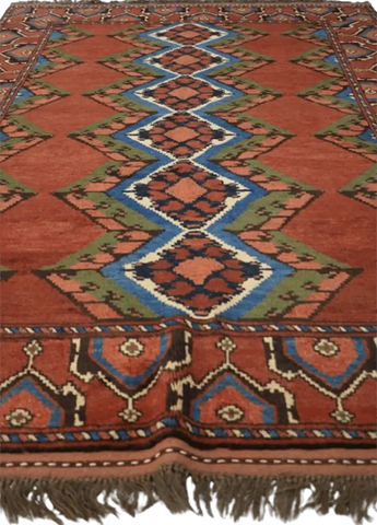 A geometric patterned Afghan Tribal Wool Rug in beige, red, and other colors.