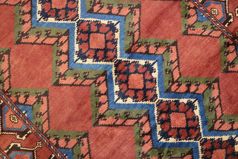 A geometric patterned Afghan Tribal Wool Rug in beige, red, and other colors.