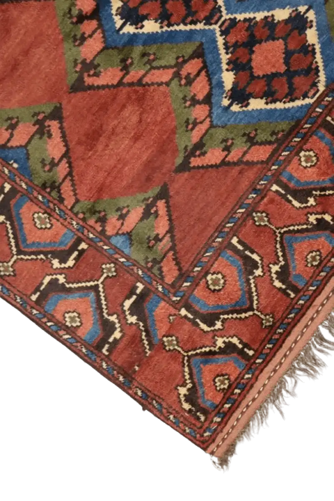 A geometric patterned Afghan Tribal Wool Rug in beige, red, and other colors.