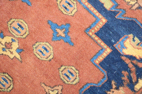 A vibrant orange and blue geometric-patterned wool rug