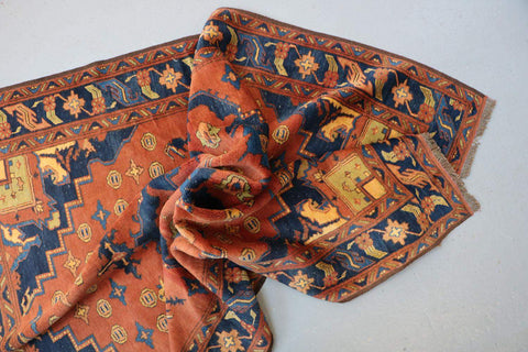 A vibrant orange and blue geometric-patterned wool rug