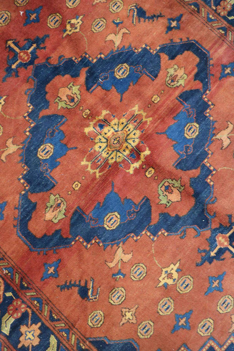 A vibrant orange and blue geometric-patterned wool rug
