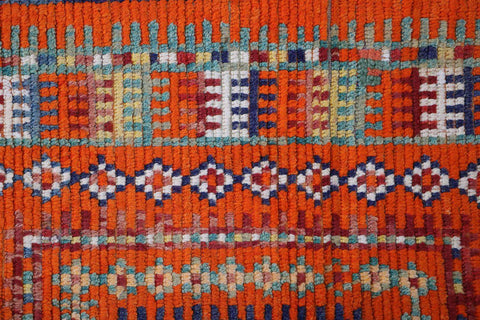 A vibrant orange and multicolored Berber tribal wool rug