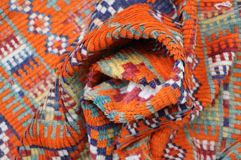 A vibrant orange and multicolored Berber tribal wool rug