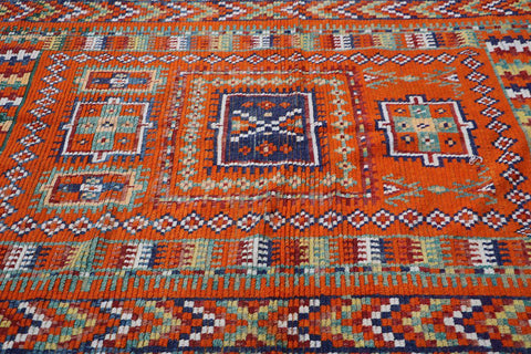 A vibrant orange and multicolored Berber tribal wool rug