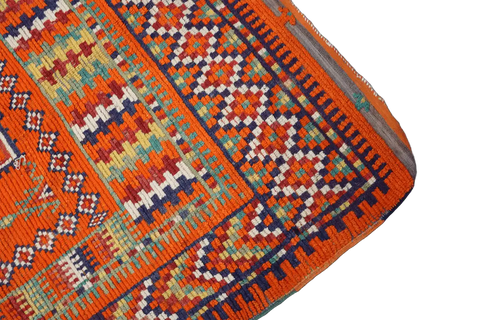 A vibrant orange and multicolored Berber tribal wool rug