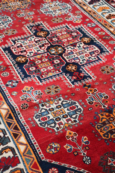 A vibrant red Persian Qashqai tribal rug