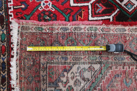 A long, rectangular, red wool rug 