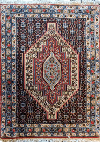 A Persian Senneh traditional wool rug with a geometric and floral pattern, predominantly brown with blue accents.